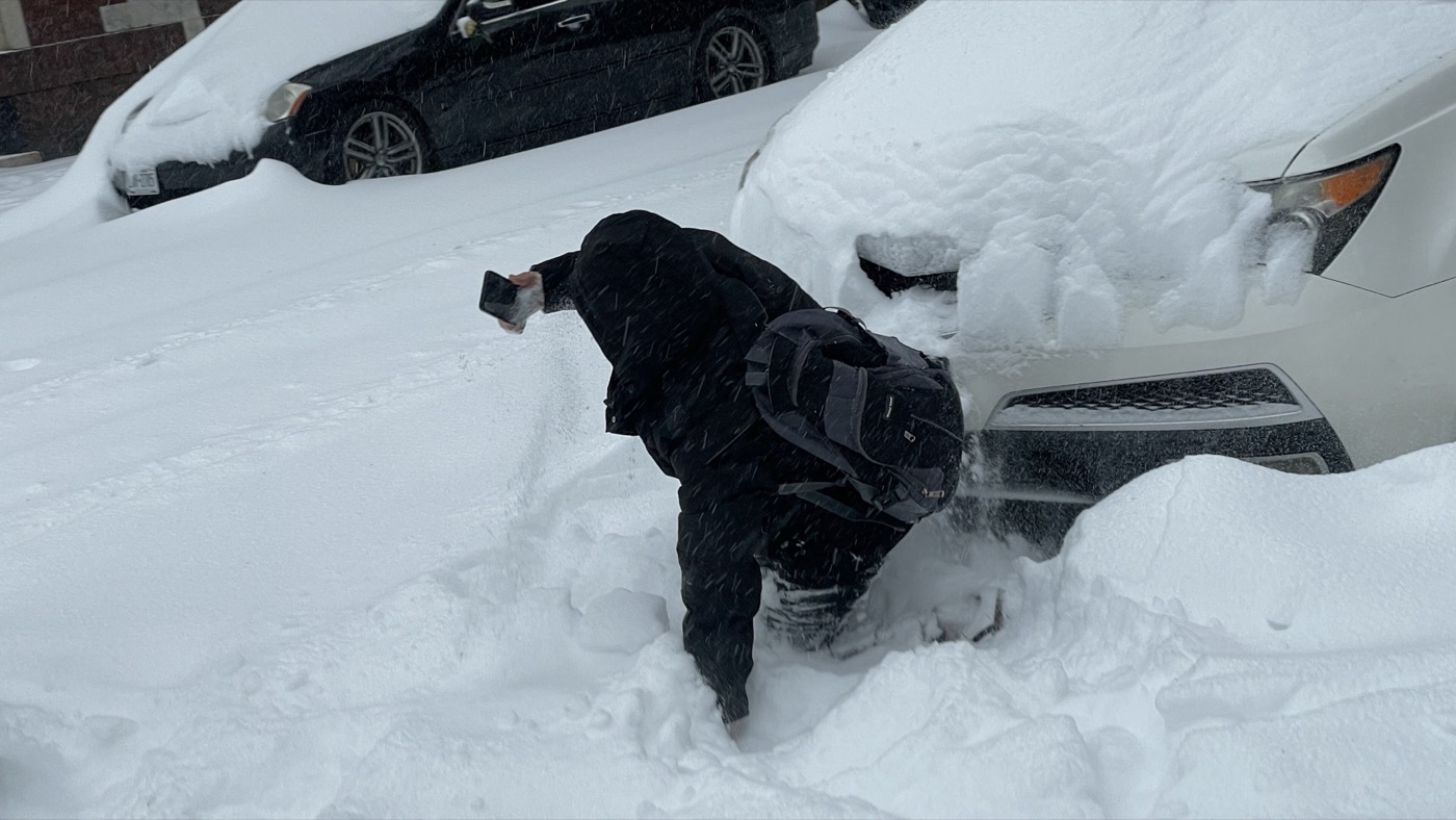 Someone using a smartphone on a snowy New York street